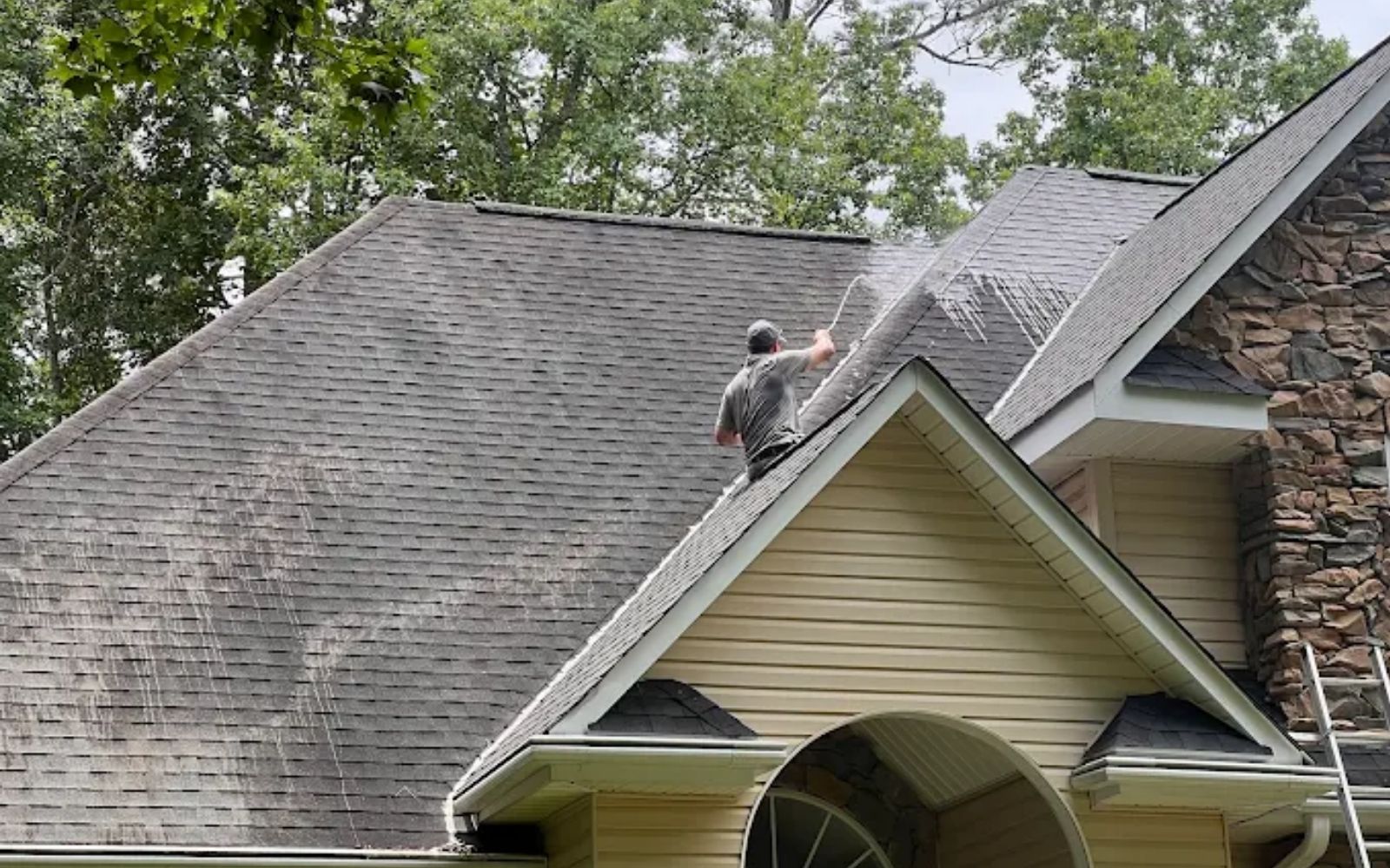 Our team soft washing a residential roof