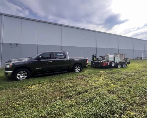 Eco Blast Pressure Washing truck and equipment parked in front of an industrial building for a commercial exterior cleaning project in Greenville and Spartanburg SC
